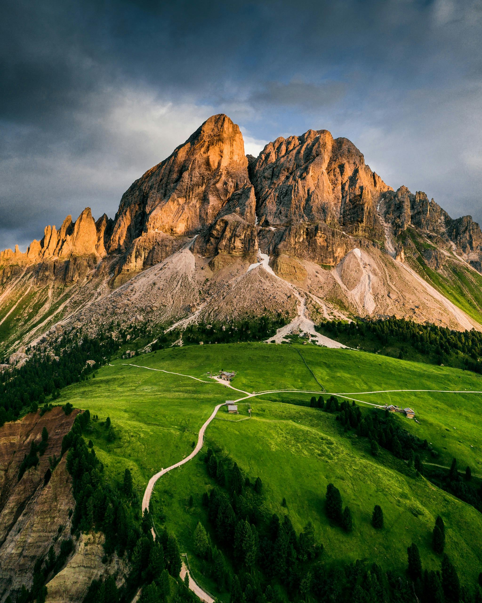 Breathtaking aerial view of sunlit mountains and lush green valleys, perfect for nature enthusiasts.