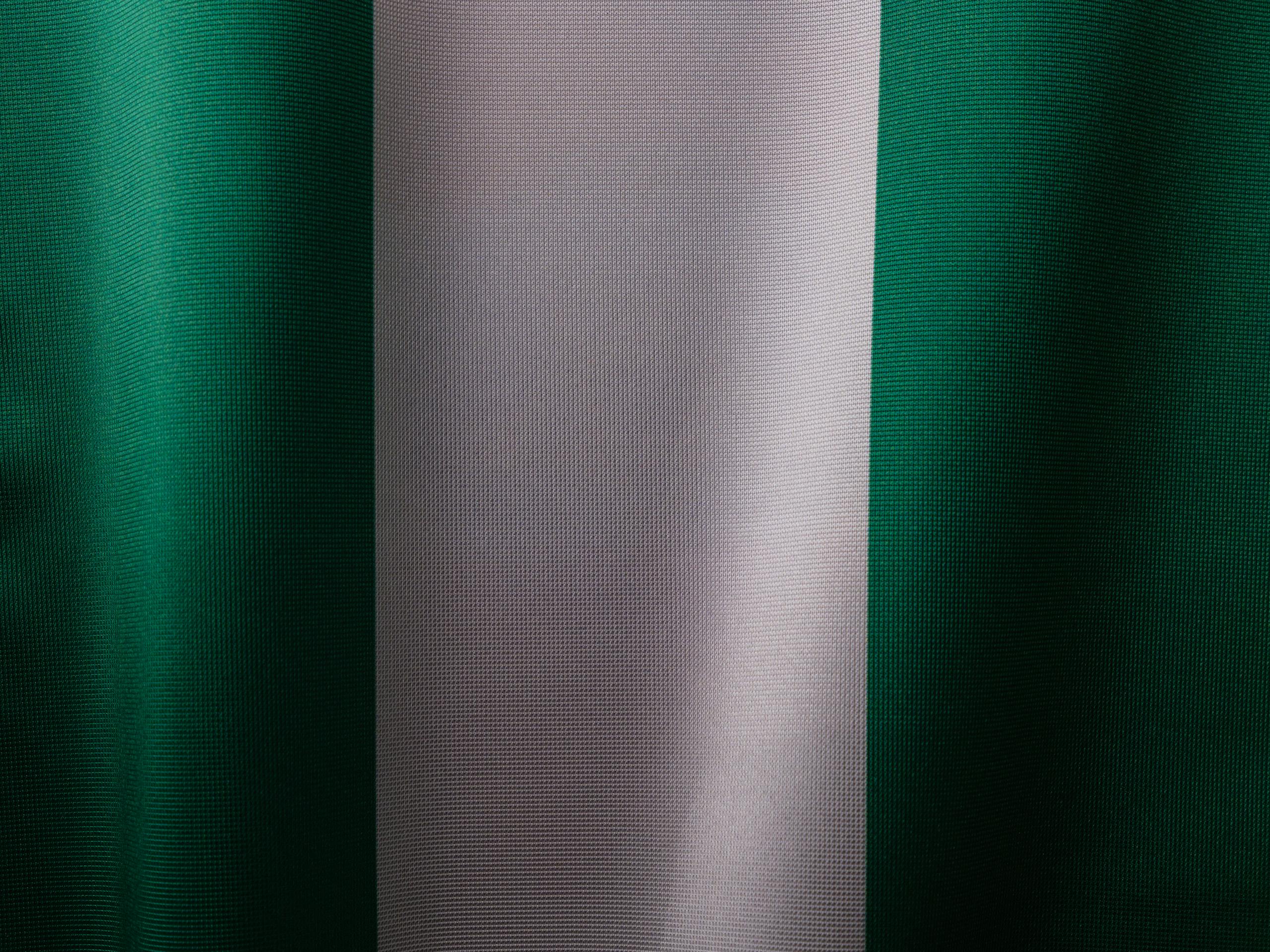 Detailed view of the Nigerian flag's textile texture, showing green and white stripes.