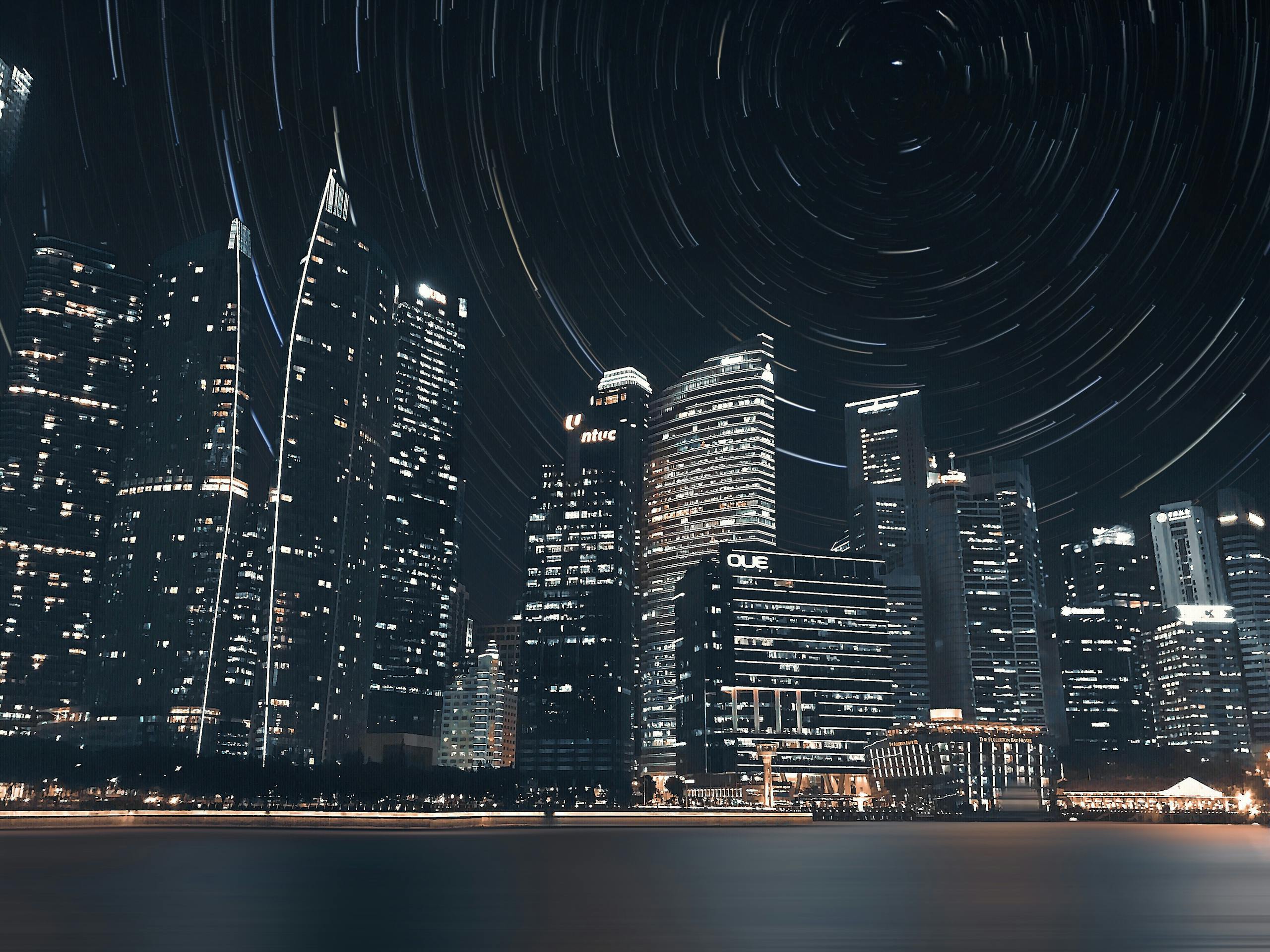 Stunning long exposure of Singapore's night skyline, highlighting skyscrapers and star trails.